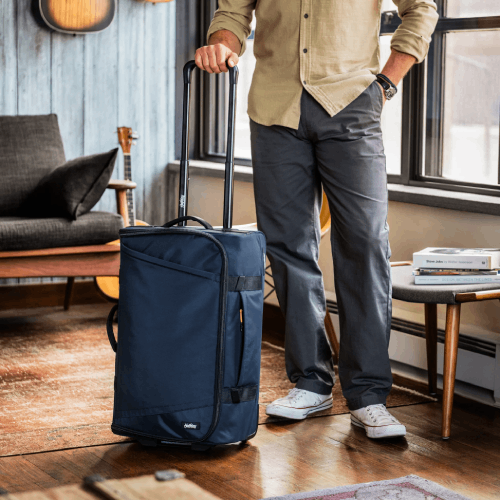 Traveler rolling a Halfday bag through a room.