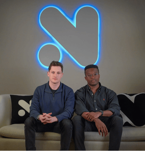 Novig founders seated in front of a Social Alchemy mark.